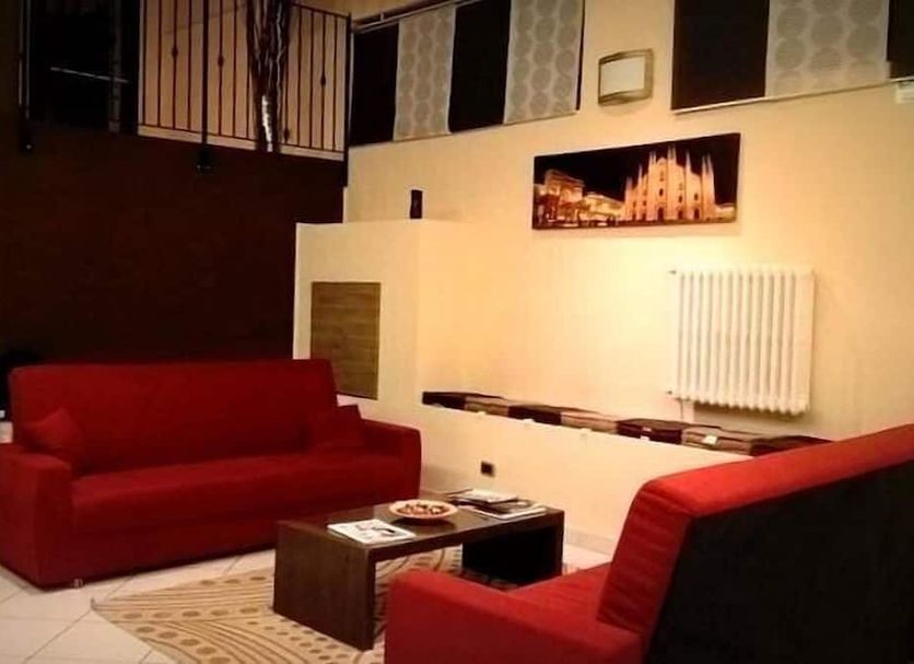 Hotel Centrale Milan lounge with red sofas, coffee table, and wall art