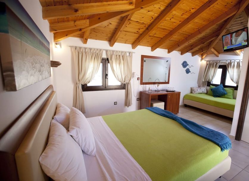 Berdoussis Hotel in Elafonisos guest room with wooden سقiling, double bed, and sitting area