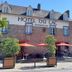 Hotel - Restaurant du Lac in Boé, stone facade with outdoor terrace and red umbrellas