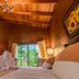 Hotel El Silencio del Campo in La Fortuna: wood-paneled suite with towel swan and garden view