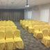 Oriental Hotel Dongguan conference room with rows of yellow-covered chairs and projector screen