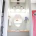 Trailhead Lodging Seward bathroom vanity with oval mirror, triple light fixture, towels and wastebasket
