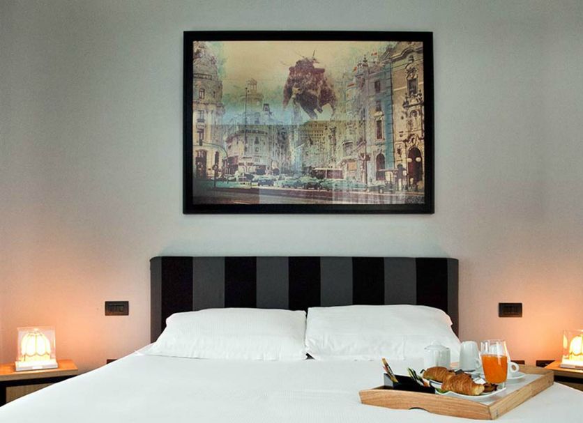 Suite Art Navona in Rome, guest room with striped headboard, framed artwork, and breakfast tray on bed