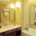 Golden Ray International Hotel in Yichang bathroom with vanity, large mirror, and glass shower enclosure