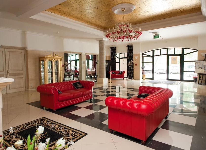 Hotel Royal Baltic 4 Luxury Boutique in Ustka lobby with red sofas and black-and-white checkered floor