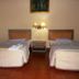 Bali Lovina Beach Cottages in Buleleng, twin beds in a simple guest room with bedside lamp and wall art
