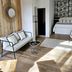 La Maison Grivolas in Avignon guest room with bed, sofa, wood accent wall and hanging pendant lights