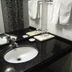 Orange Crystal Hotel Xuzhou Suning Plaza bathroom sink with black countertop and towels