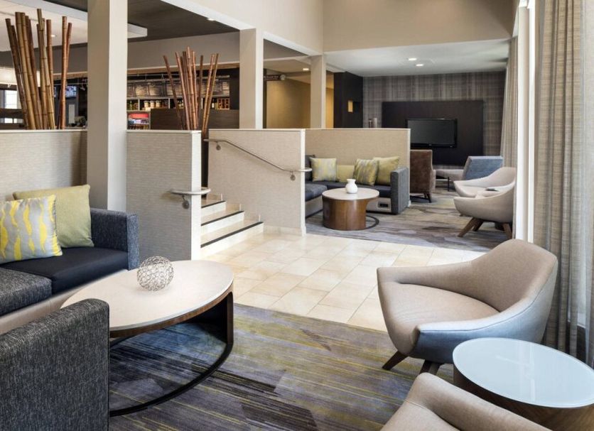 Courtyard by Marriott San Mateo Foster City lobby seating area with sofas, chairs and a TV