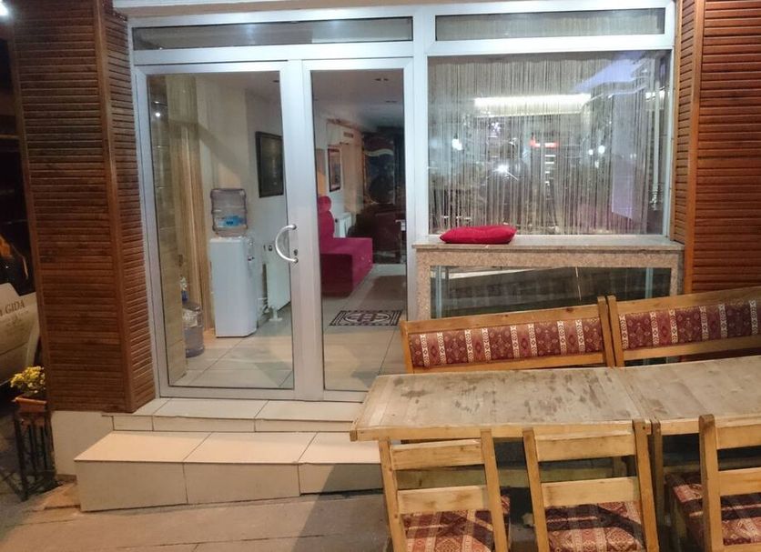 Hotel Yasmin in Istanbul exterior with sliding glass doors, patio table, and bench seating