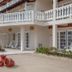 The Colonial at Jaguar Reef in Hopkins with white balconies, exterior stairs, and sandy courtyard