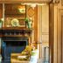 The Wood Norton in Evesham features an ornate wood-paneled lounge with fireplace and armchair.
