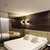 Iris Hotel Erbusco guest room with king bed, mirrored wall and modern wood-paneled headboard