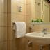 Villa Olivia Split bathroom with wall-mounted sink, mirror, towel rack and beige tile walls