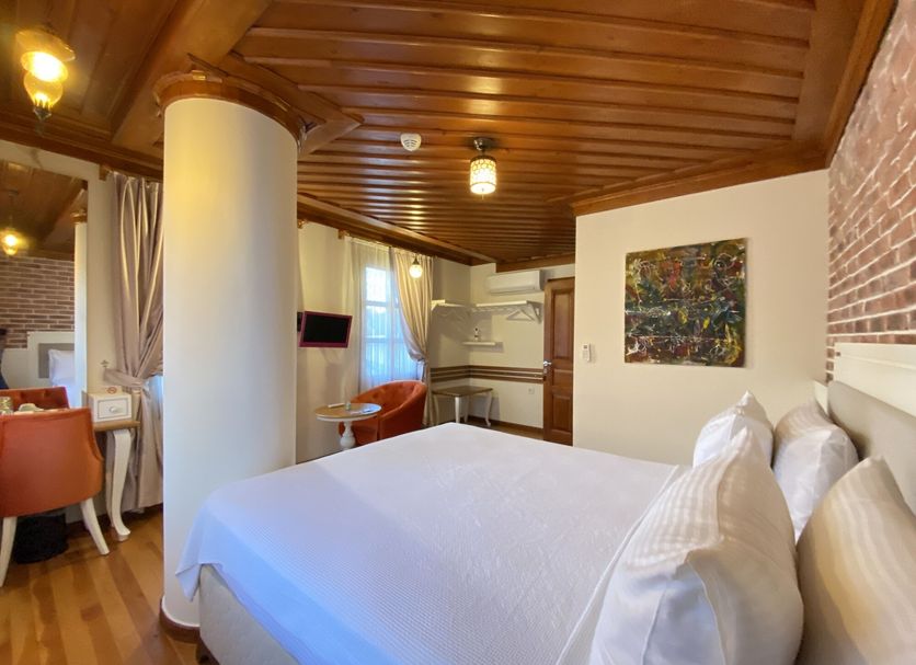 Kervan Hotel in Antalya guest room with bed, wood ceiling, dining nook and kitchenette