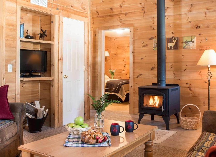 Sterling Ridge Resort in Jeffersonville cabin with wood stove, living room seating, and bedroom doorway