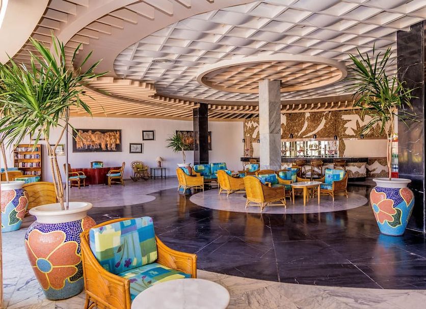 Time Coral Nuweiba Resort lobby with colorful seating, patterned ceiling, and potted palms in Nuweiba
