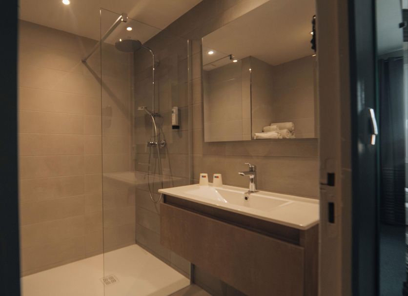 Hôtel Parc Adélie - Logis Hôtels bathroom with glass shower, vanity sink and mirror in Montagny-lès-Beaune