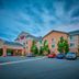 Fairfield Inn & Suites by Marriott Burlington exterior with entrance, parked cars, and evening sky