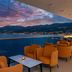 Hilton Rijeka Costabella Beach Resort & Spa terrace seating with sunset sea and mountain views in Rijeka