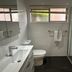 The Oaks Hotel Motel Wollongong bathroom with shower, toilet, sink and window