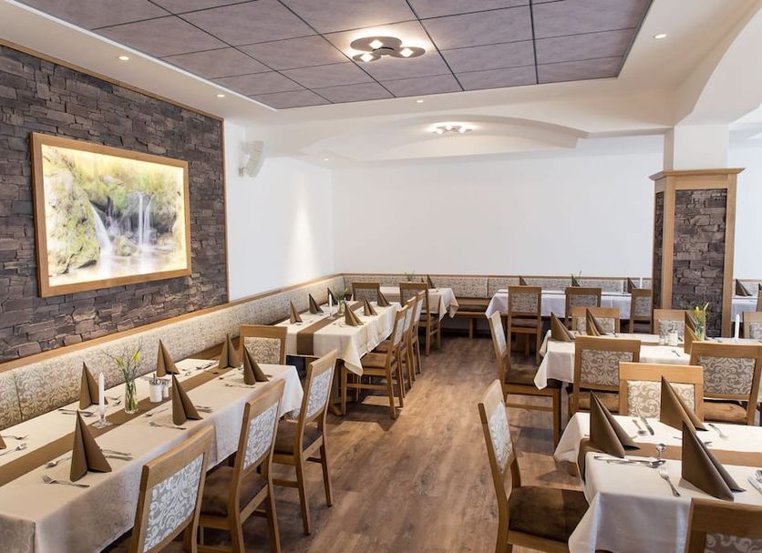 Hotel Landgasthof Hohenauer Hof restaurant dining room in Hohenau with set tables and stone accent wall