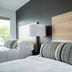 The Waypoint in Rehoboth Beach hotel room with white beds, wood headboard, and patterned bolster pillow