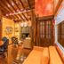 DPNY Beach Hotel in Ilhabela lounge with wood-paneled ceiling, dining table, sofa, and garden view