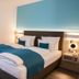 Kapuzinerhof in Biberach an der Riß: modern twin bed with blue accents and balcony door