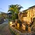 Anew Resort White River Mbombela courtyard with stone fountain, palm trees and lit pathway at dusk