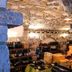 Lokanda Devetak wine cellar with stone vaulted ceiling and wooden shelves in Capriva del Friuli
