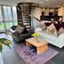 Dolgun Uchaf Guesthouse in Dolgellau: cozy lounge with leather chair, sofa, spiral stairs and kitchen area