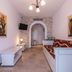 Plaza Beach Hotel in Plaka guest room with twin beds, wall TV, and arched doorway