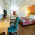 Motel 6 Clarksville Tn guest room with king bed, desk, chair, and orange accent wall in Clarksville