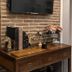 The Print House Hotel Istanbul interior with brick wall, wooden console, books, decor, and TV