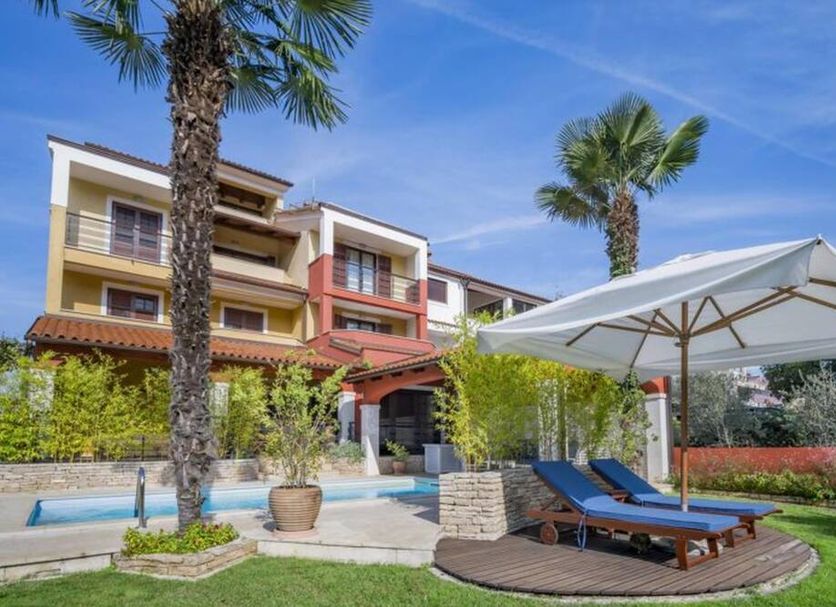 Apartments with Pool Villa Rossella 1 in Rovinj, poolside loungers and palm trees by the building