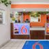 Motel 6 King City Ca lobby with front desk, orange accent wall, potted plants and tiled floor