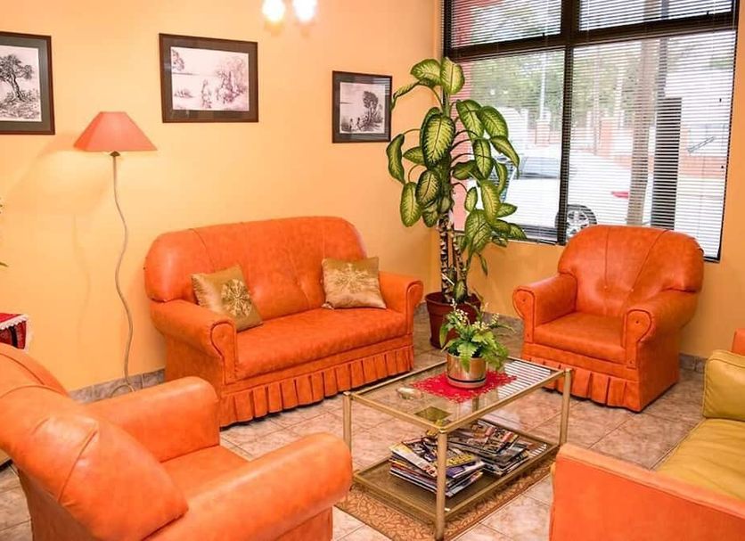 Hosteria Maryland in Posadas lobby with orange seating, glass coffee table and large window