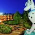 Disney's All-Star Movies Resort in Bay Lake with giant Dalmatian statues and lit courtyard at dusk