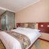 Jinan Jier Hotel room in Jinan with a bed, glass shower enclosure, and desk area