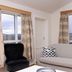 Guesthouse Brekka in Husavik room with two windows, sofa, armchair and countryside view