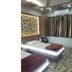 Nice Guest House Mumbai room with two single beds, patterned curtains, and wall panel headboard
