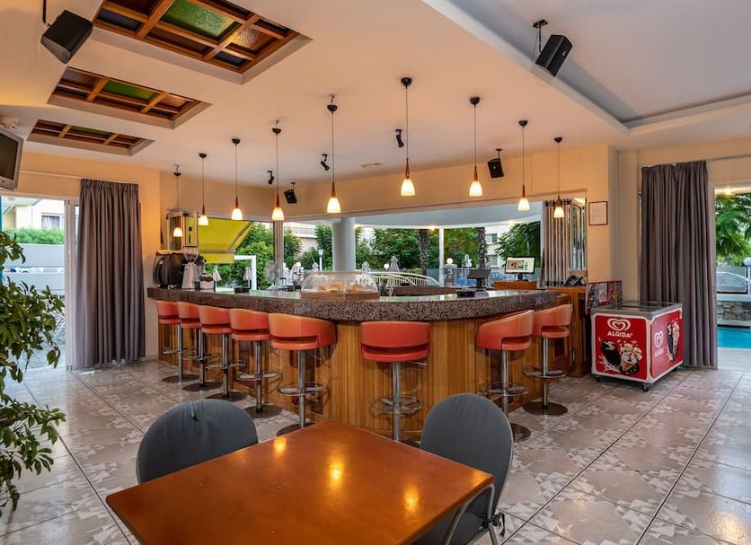 Angela hotel in Kos with a bar and stools beside pool-view seating area