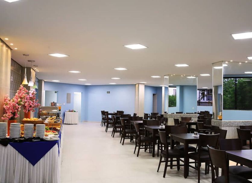 Golden Dolphin Supreme in Caldas Novas dining area with tables, chairs, buffet setup and bright ceiling lights