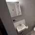 The Macaw Guesthouse in New York bathroom with small sink, toilet, mirror and patterned shower curtain