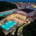 Mavrikos Hotel, Tsilivi: aerial view of a lit outdoor pool terrace near the coast at dusk