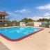 Motel 6 Meridian Ms outdoor pool with lounge chairs and motel exterior in Meridian