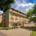 Hungarospa Thermal Hotel in Hajdúszoboszló with a covered entrance and tree-lined exterior