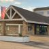 Motel 6 Norway MI exterior with stone facade, gabled roof, and American flag in Norway