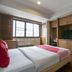 Hotel Win Long Bangkok guest room with bed, TV cabinet, window and wood cabinetry
